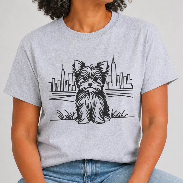 Heather grey t-shirt with a white line art Yorkshire terrier sitting in grass in front of the NYC skyline and Empire State Building.
